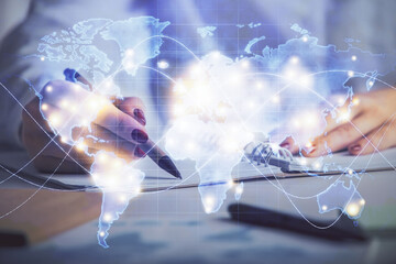 International business hologram over hands taking notes background. Concept of success. Multi exposure