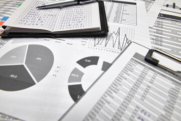 Top view of office employee's desk - work with financial reports, analysis and accounting, tables and graphs, various office items for bookkeeping