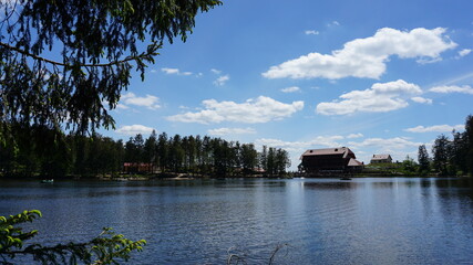 Fototapeta premium the view of a house at the Lake Mummelsee in the Black Forest in the month of May, Germany