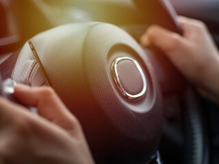 The hand is holding the steering wheel to drive the car,Because while driving, you need to...