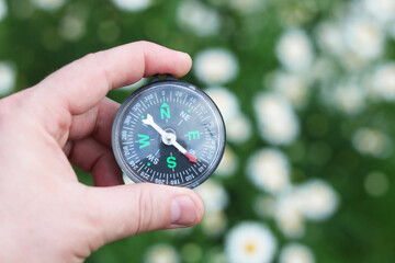 Old classic navigation compass in hand on natural background