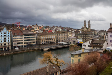 Obraz premium Zurich old town at cloudy winter sky. Cityscape from above with beautiful street.Switzerland landscape before sunset in rainy season. Slow speed shutter.
