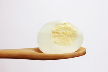 Half Egg on spoon  on white background .