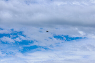 Blue sky and airplane through the clouds