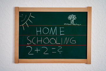Kreidetafel mit Mathematik Aufgaben. Eltern müssen die Aufgaben der Schule übernehmen. Home Schooling hat sich in der Zeit von Covid 19 etabliert. 