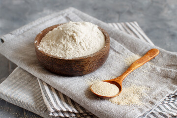 Fototapeta na wymiar Bowl of Raw fonio flour and a spoon of fonio seeds