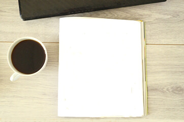 A cup of coffee, empty place in journal and notebook on wooden table, mockup