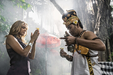 Asia, Indonesia, Bali, young, beautiful Caucasian woman wearing smart casual clothing, enjoying a local cultural experience, being blessed by a Balinese Hindu high priest, (a Padanda).