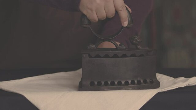 Man ironing clothes with an old vintage iron