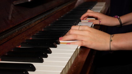 hands of the child playing piano