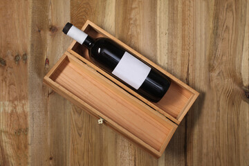 wooden wine box with a red wine bottle inside  rest on a wooden table with copy space for your text