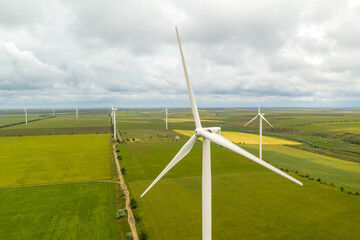 Fototapeta na wymiar Aerial view of wind turbines in field on cloudy day