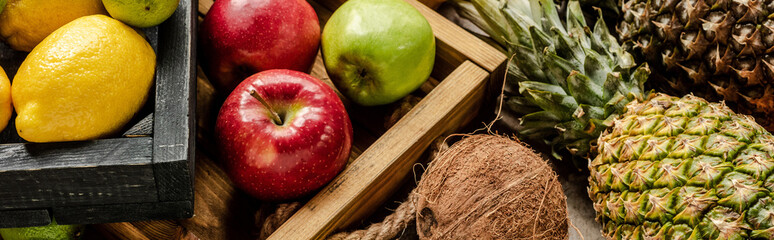 panoramic shot of ripe fresh fruits in wooden boxes