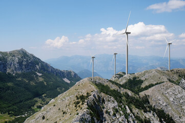 Fototapeta na wymiar Alternative energy source. Wind turbines and mountains outdoors