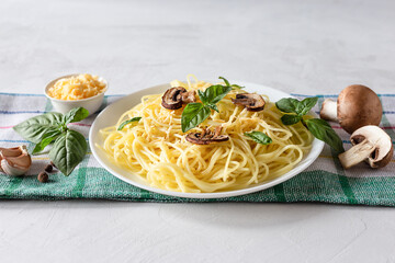Delicious delicious pasta with mushrooms and Basil on a gray background. Italian food concept. Copy space