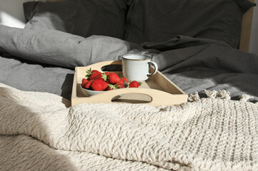 Unmade bed with breakfast at sunlight