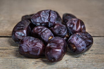 Fresh dates on wooden table, sort mazafati, sweet vegan superfruit