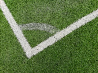 A corner arc marking on green grass pitch