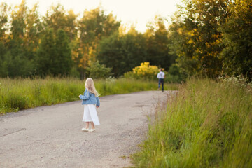 Fototapeta premium Children girl and boy siblings running on the road. Back view. The concept of summer, childhood, freedom, fun outdoors. Soft focus.