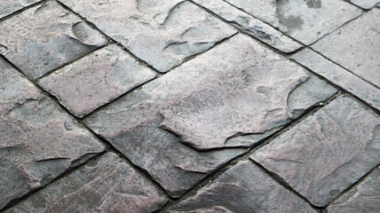 Concrete or cobblestone gray paving slabs or stones for the floor. Pavement in the city. Large gray paving tiles close up.