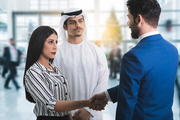 Businessman And Businesswoman Shaking Hands In Office. Arab business concept.