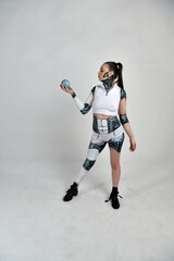 beautiful brunette girl in a robot suit holds a model of our planet in her hands and studies it