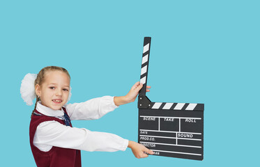 Child  with cinema clapperboard on blue color background.