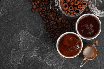 White coffee cup with with beans on dark surface