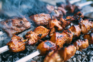 Skewers of pork ribs and chicken on skewers. Grilled meat. Cooking outdoors..