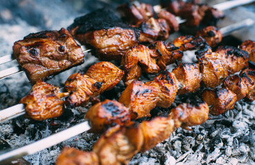Skewers of pork ribs and chicken on skewers. Grilled meat. Cooking outdoors..