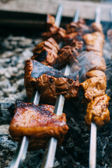 Skewers of pork ribs on a skewer in smoke. Cooking meat in nature..
