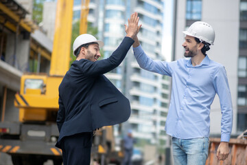 Foreman and building supervisor giving each other high five