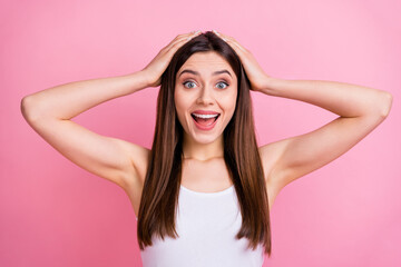 Fototapeta premium Closeup photo of pretty shocked lady long perfect hairstyle listen amazing news open mouth arms on head wear casual white singlet isolated pastel pink color background