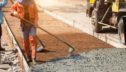 Workers pouring concrete with a cement mixer truck