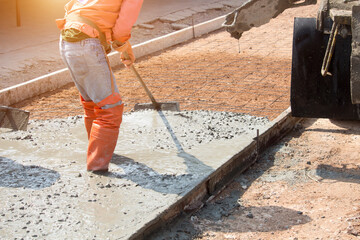 Workers pouring concrete with a cement mixer truck