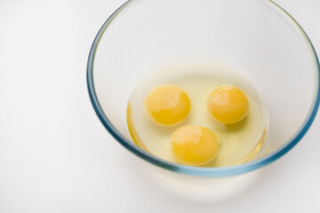 egg yolk in a bowl, a raw egg, eggs on a white background