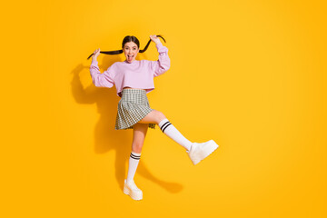 Portrait of funny childish youth hold her tails show tongue out feel foolish on spring weekend holiday wear plaid sneakers pullover isolated over bright color background