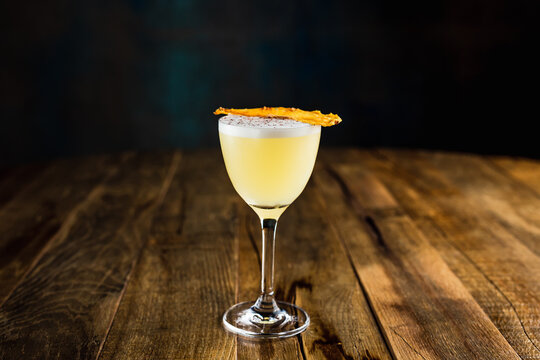 A pineapple sour cocktail in a nick and nora glass
