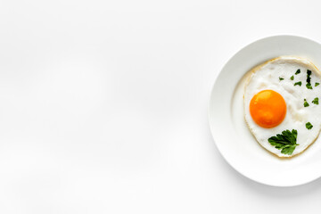 Fried eggs on plate - white dinner table from above copy space
