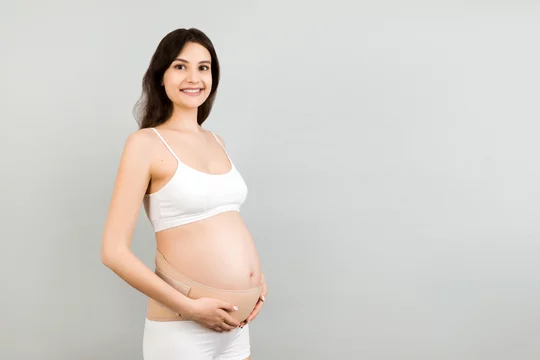 Premium Photo  Portrait of pregnant woman in underwear wearing pregnancy  belt at blue surface with copy space. orthopedic abdominal support belt  concept.