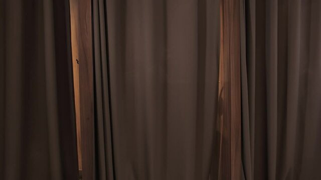 A stylish man in a suit with a beard pushes back the curtain in the fitting room and goes to the checkout.