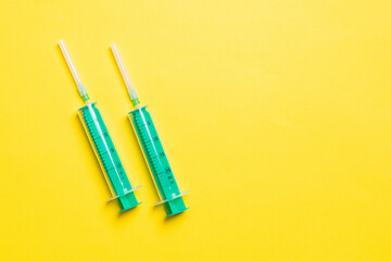 Top view of different syringes for injection on colorful background. Medical equipment concept with...