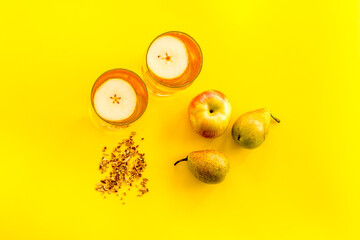 Fruit drinks with apple and pear on yellow background from above