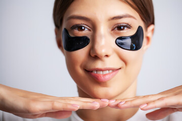 Beauty care, young beautiful woman with black patches for skin care under the eyes