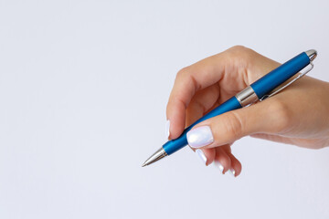 Gesture and sign, female hand holding a metal blue pen on a white background