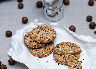 Homemade cookies with sesame seeds. A coffee maker  is in the background.