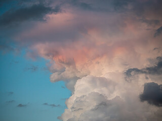 Dramatische Wolkenformation mit hellen, rötlichen und dunklen Wolken vor blauem Abendhimmel