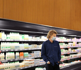 Supermarket shopping, face mask and gloves,Young man shopping in supermarket, reading product information