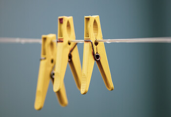 A plastic clothespin hangs on a clothesline