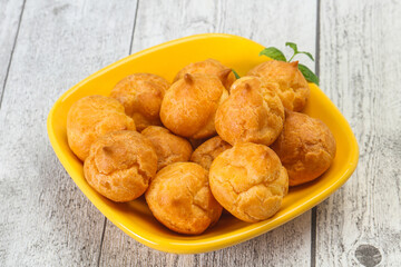Sweet tasty profiteroles heap in the bowl